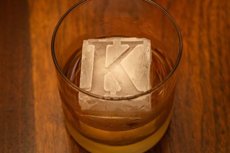 glass of whiskey & ice cube embossed with letter K