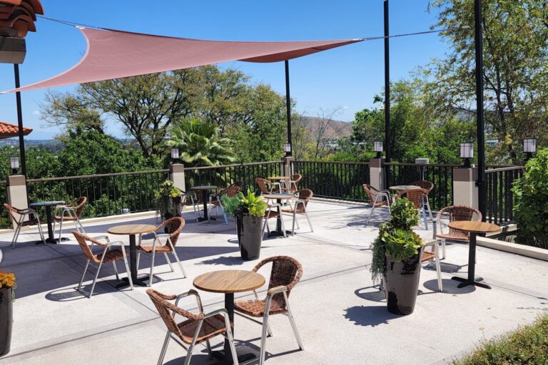 Outdoor patio with tables, chairs, and potted plants