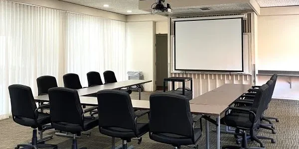 Room with C shapes sitting and with a LCD projector and screen