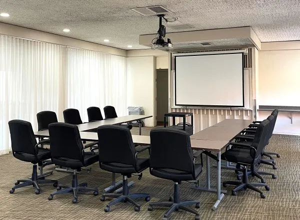 Room with C shapes sitting and with a LCD projector and screen