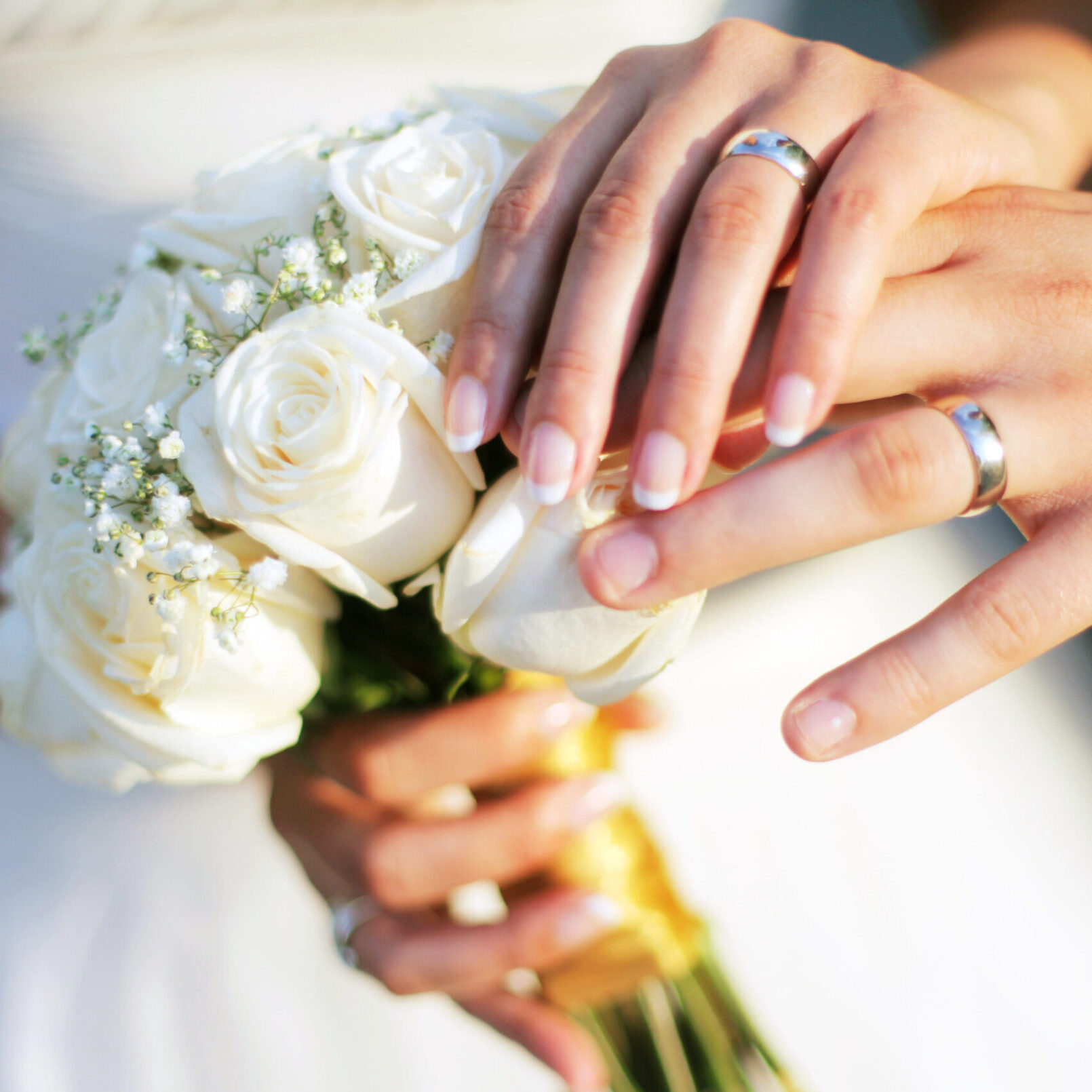 Wedding rings, bouqet and hands holding