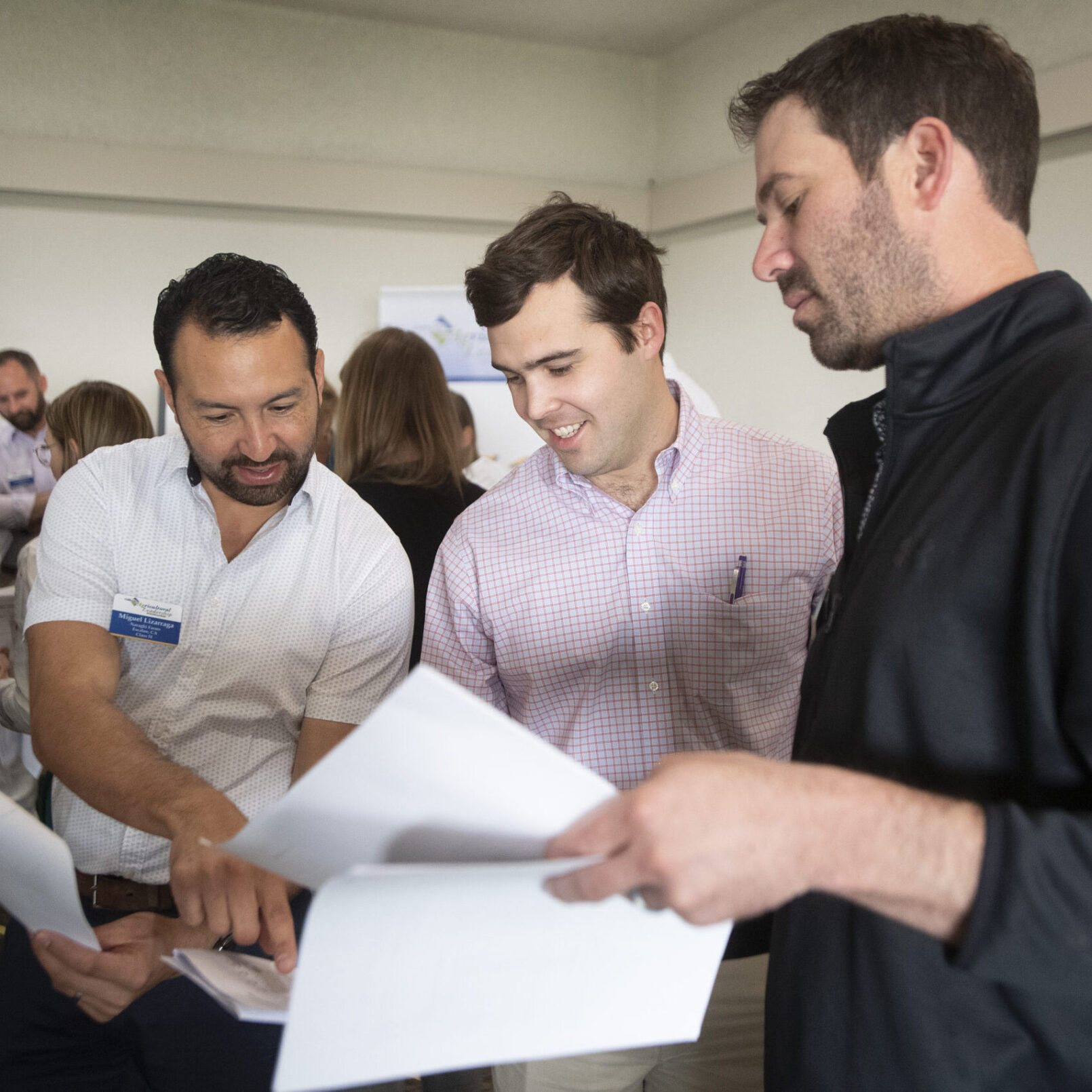 Three business men meet to look over paperwork