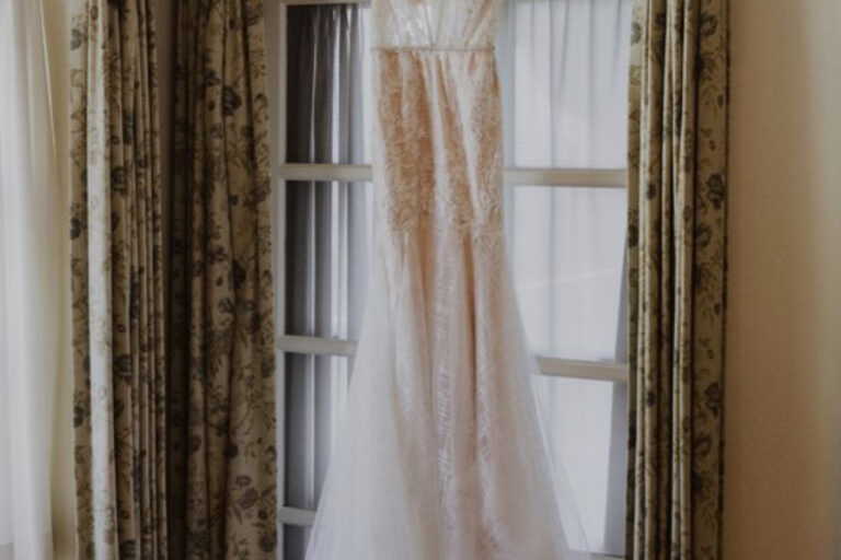 wedding dress hanging in window
