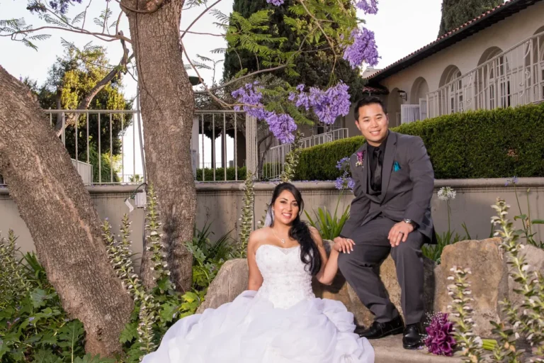 Bride and groom pose for photo in back yard of Kellogg House